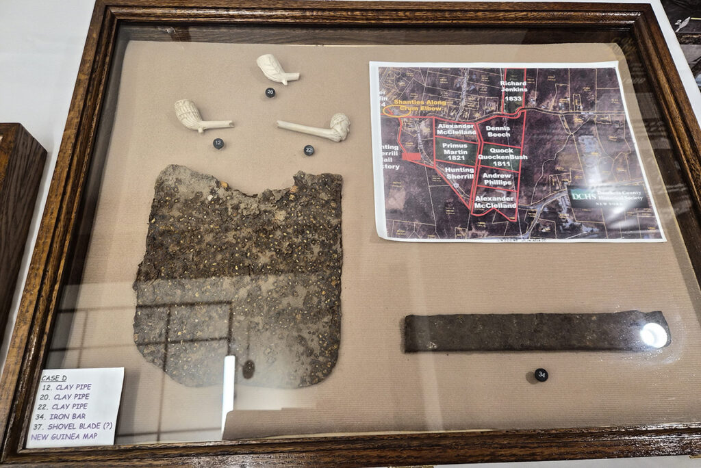 Framed display case with artifacts and map