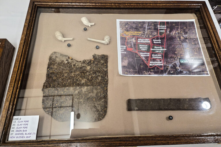 Framed display case with artifacts and map
